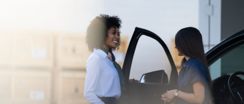 A person exits a GM vehicle while talking with a salesperson after taking a test drive.