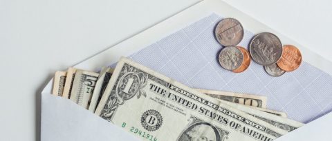 White envelope filled with cash and coins 