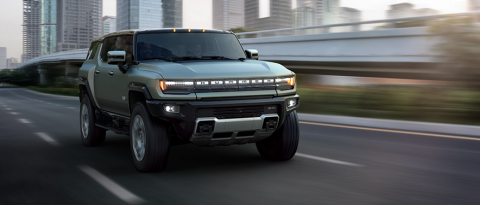 GMC HUMMER EV driving past a cityscape