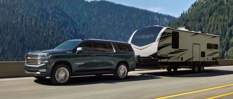 Blue Chevrolet Suburban towing an RV
