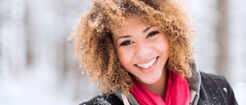 mujer sonriendo con confianza frente a una computadora