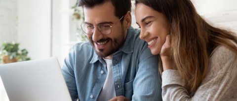 Pareja sonriente trabajando juntos dentro del presupuesto