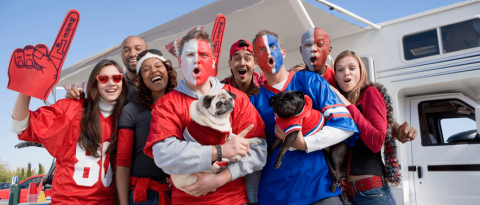 Una multitud de fanáticos de los deportes y dos perros celebrando