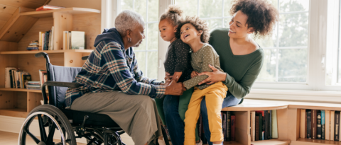 Older woman in a wheelchair visits with her daughter and granddaughters in a library