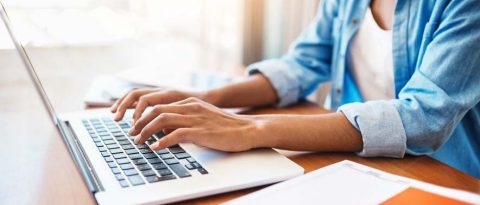 A woman typing on a laptop