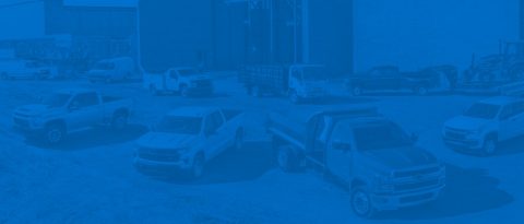 Different vehicles in front of a jobsite.