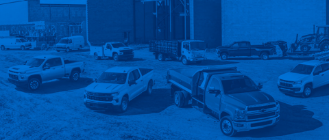 Different vehicles in front of a jobsite.