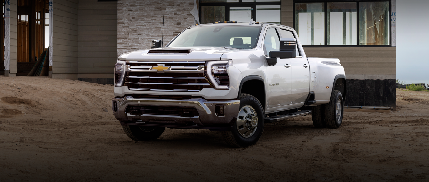 A white Chevrolet pickup truck in front of a newly constructed building