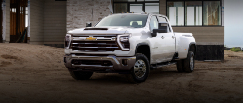 A white Chevrolet pickup truck in front of a newly constructed building