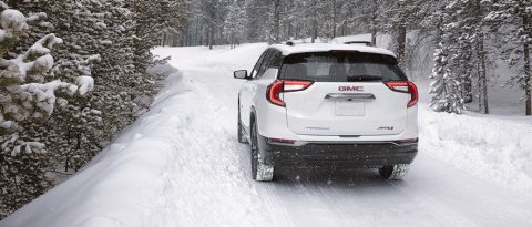 Terreno blanco de GMC en una carretera de montaña nevada