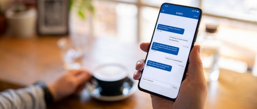 Person chatting with GM Financial’s virtual assistant, Nanci, on their phone while having coffee.