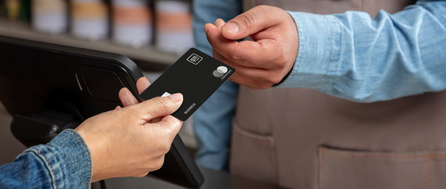 Person using a black GM Rewards Mastercard at a hardware store.