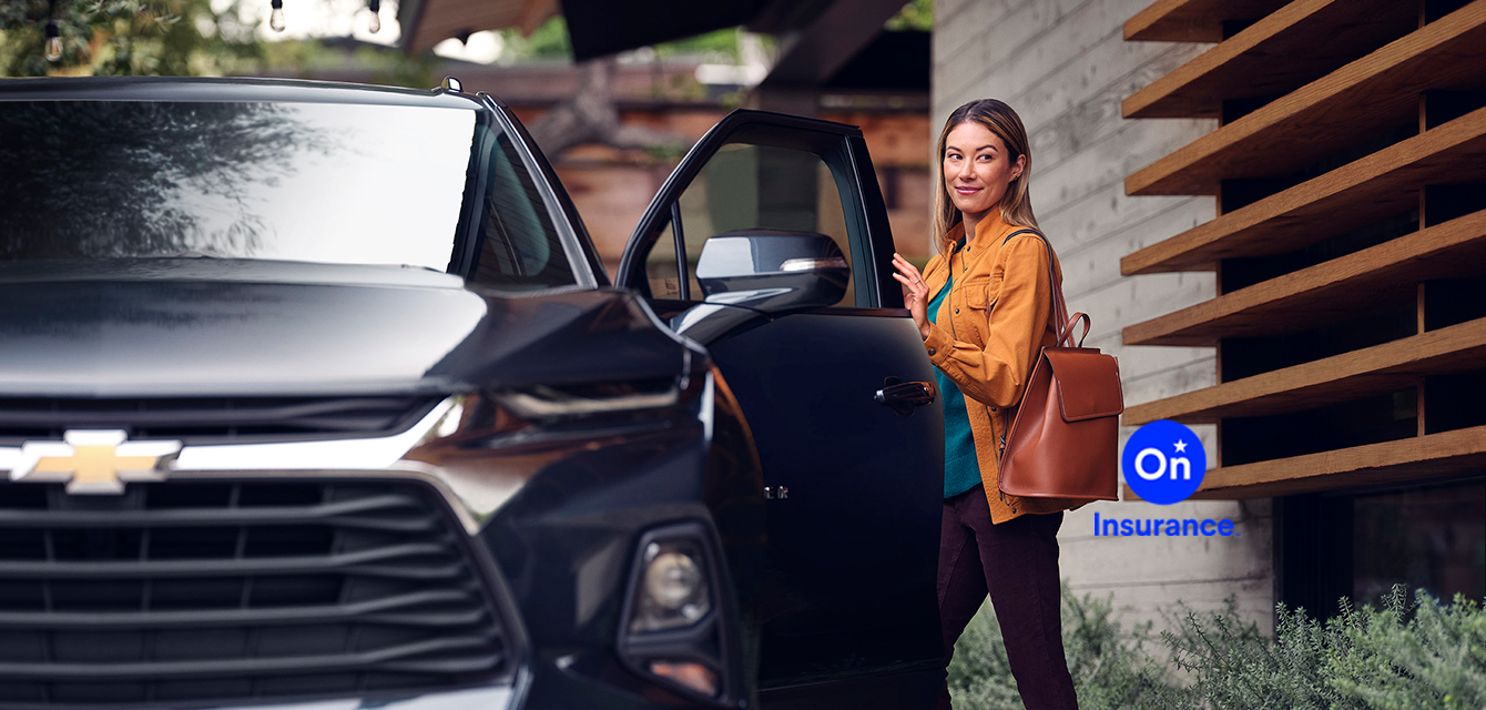 Mujer paseando a su perro junto a un Chevrolet Blazer. General Motors Insurance