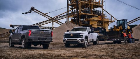 Two GM trucks at a construction site.